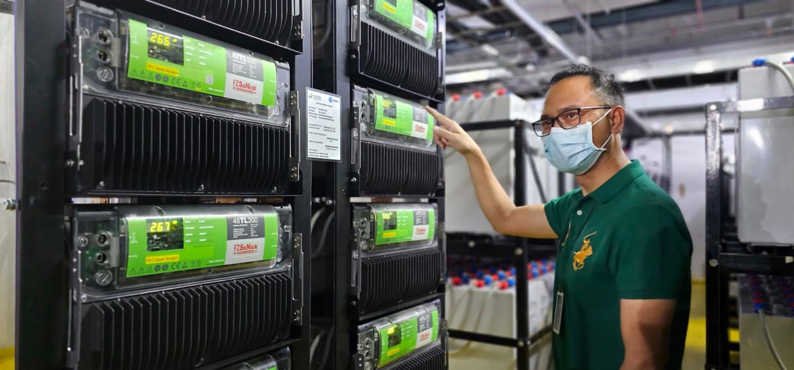 Core Network Facilities Manager Herbert Frias inspects batteries at a Globe site in Metro Manila.