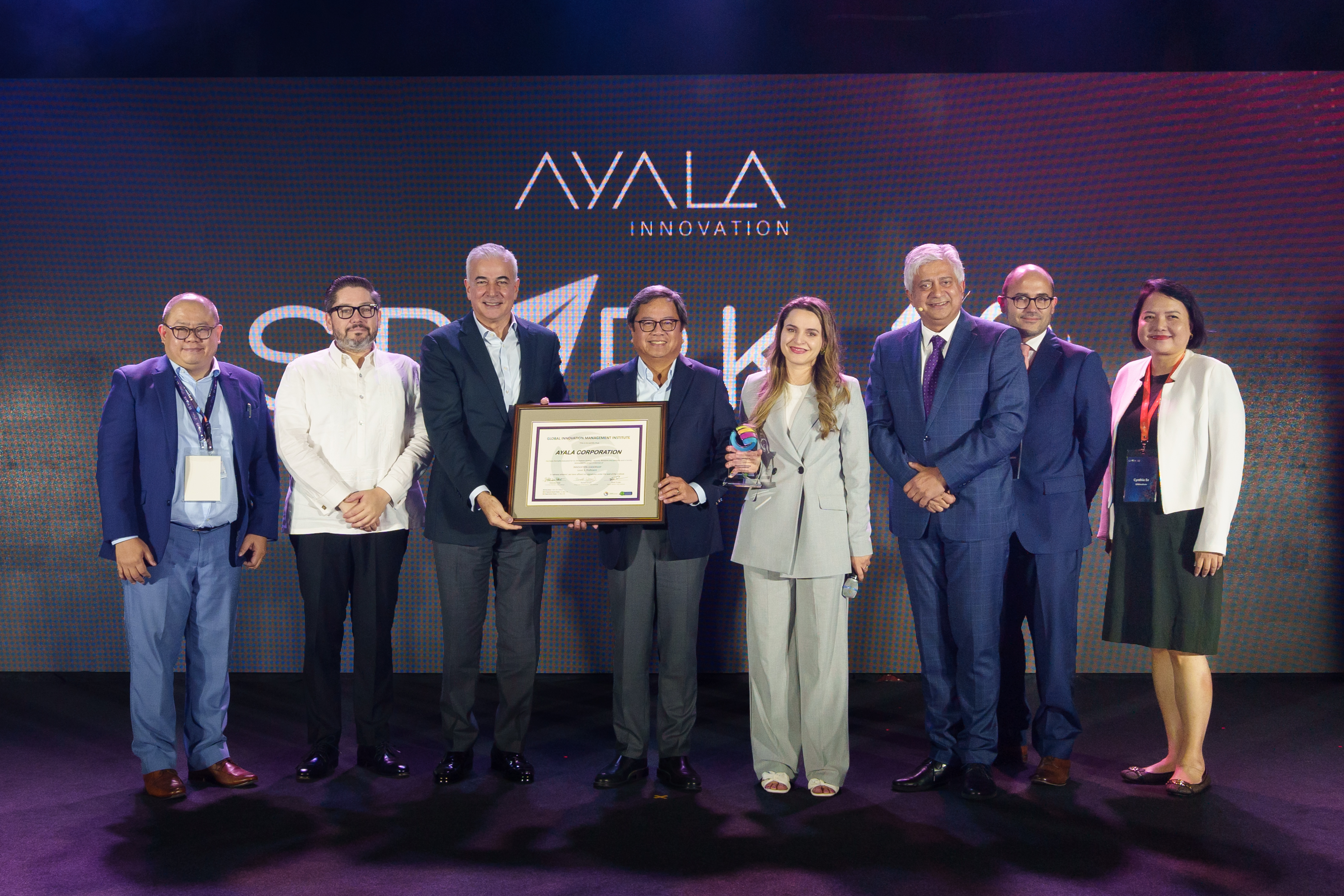 Ayala Board Director Fernando Zobel de Ayala and President and CEO Cezar “Bong” Consing, together with Innovation Head Vince Tobias and Chief HR Officer Francisco Romero Milán, proudly present the Level 3 certification awarded by the Global Innovation Management Institute's COO Erila Haska, CEO Hitendra Patel, Board Director Rafael Lemaitre, and Certified Training Partner Cynthia Ee